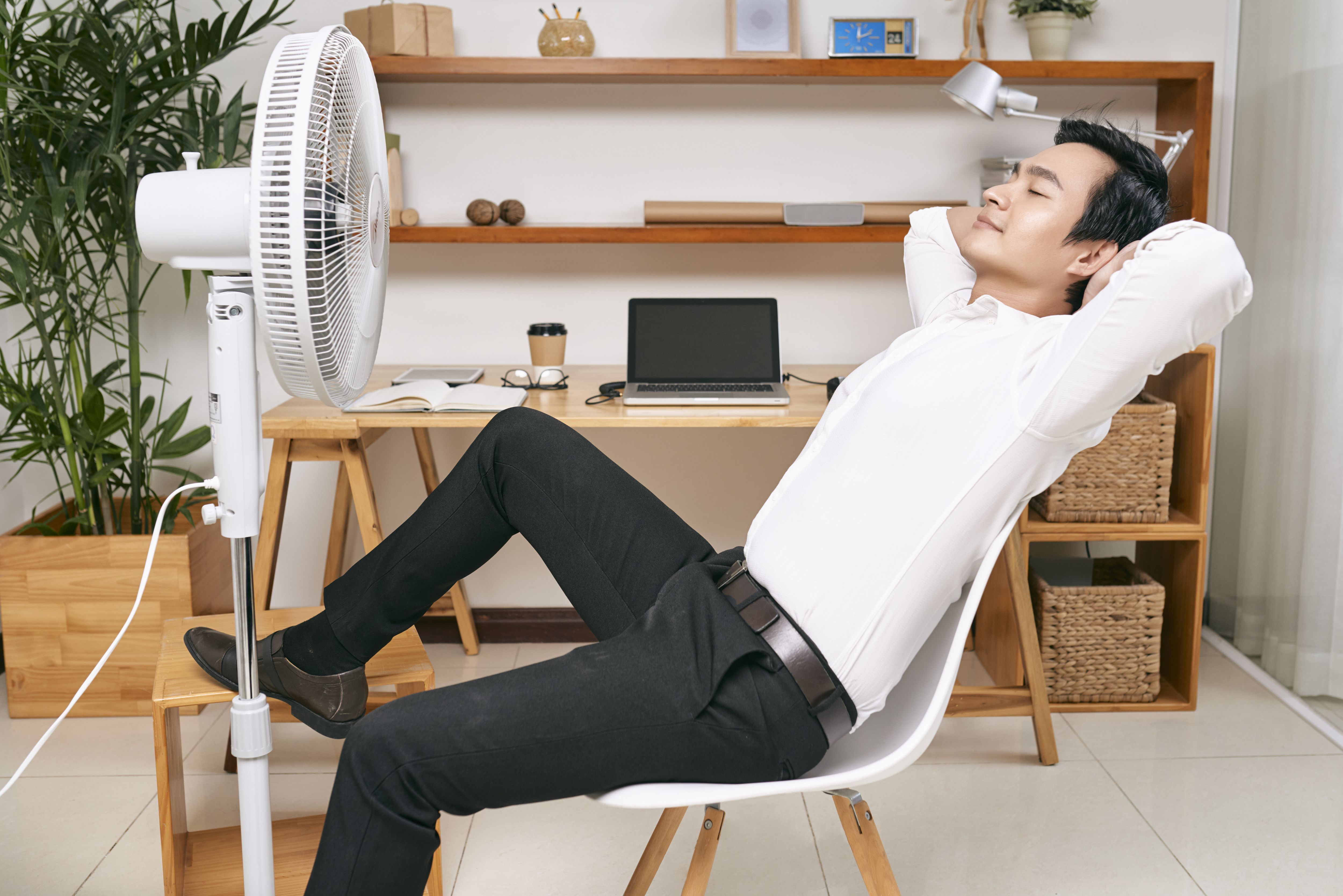 homem em frente ao ventilador em um dia de calor extremo